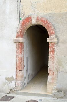Small passage under a house with a porch in stone arch of France in the town of Bar le Duc in the department of Meuse in France
