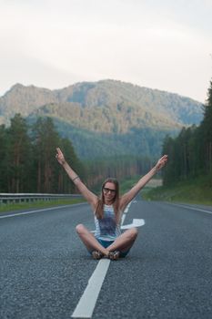 Woman sitting on the beauty road in mountain