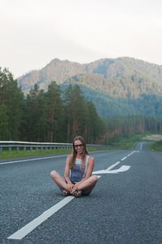 Woman sitting on the beauty road in mountain