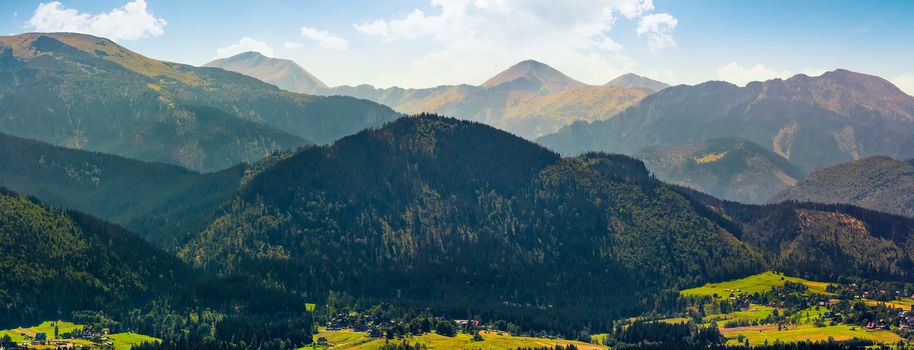 Panorama of High Tatras mountain ridge in Poland Countryside. Resort village Zakopane can be seen at the foot of the hill