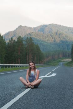 Woman sitting on the beauty road in mountain