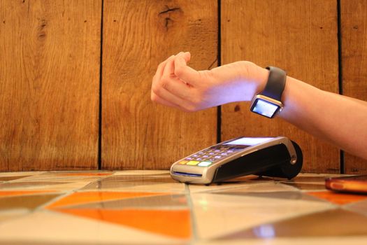 contactless payment watch smart pdq with hand holding credit card ready to pay