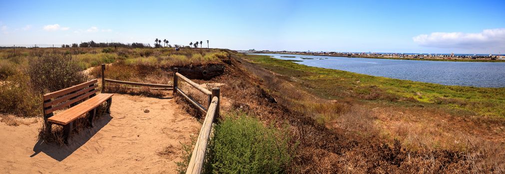 Bench overlooking the peaceful and tranquil marsh of Bolsa Chica wetlands in Huntington Beach, California, USA