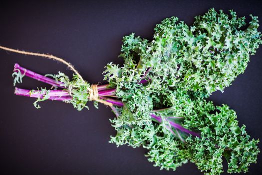 A bunch of fresh Kale salad on a wooden table