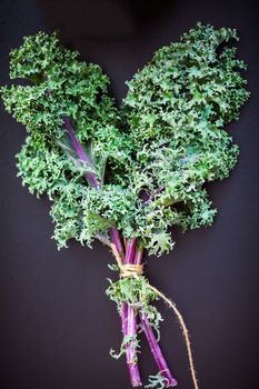 A bunch of fresh Kale salad on a wooden table