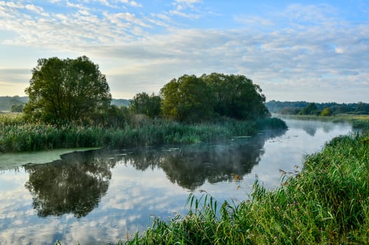 Photo with a sunny summer sunrise over the river.