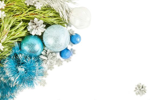 Fir tree branch and cones with blue balls and tinsel isolated on white background