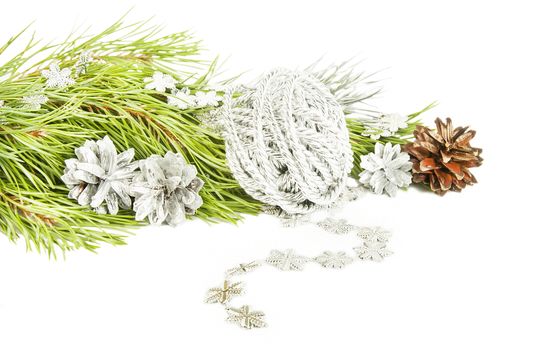 Fir tree branch, silver cones and star garland isolated on white background 