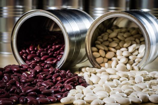 Delicious beans in a metal jar on a wooden kitchen table. Black background.