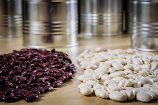 Delicious beans in a metal jar on a wooden kitchen table. Black background.