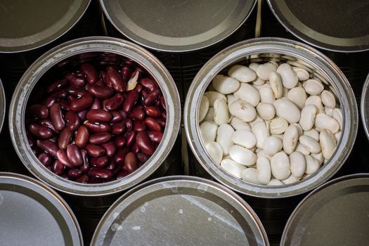 Delicious beans in a metal jar on a wooden kitchen table. Black background.