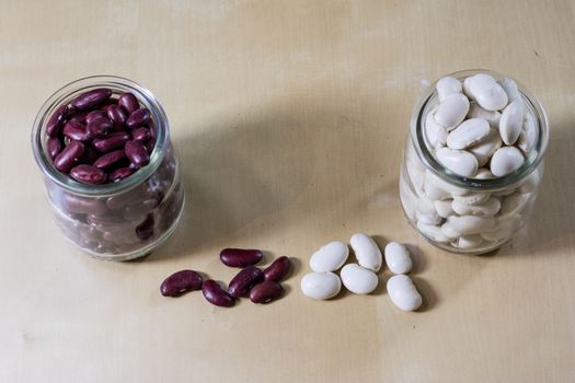 Delicious bean in a glass jar on a wooden kitchen table. Black background.