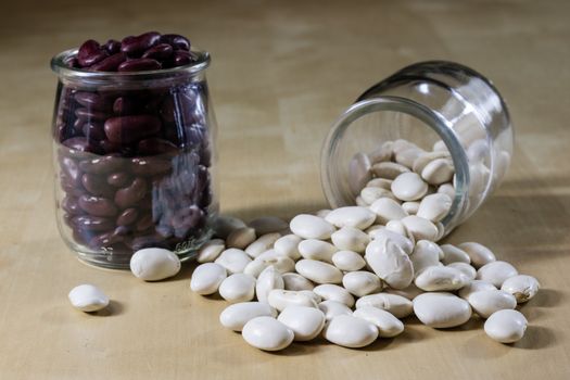 Delicious bean in a glass jar on a wooden kitchen table. Black background.