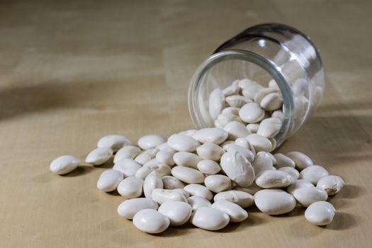 Delicious bean in a glass jar on a wooden kitchen table. Black background.