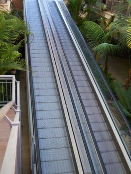 Modern walkway escalator in a mall for people with supermarket carts and disabled people