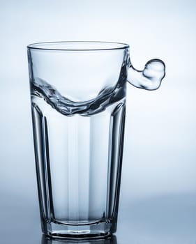 water splashing out of a glass on blue background