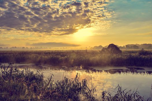 Photo with a sunny summer sunrise over the river.