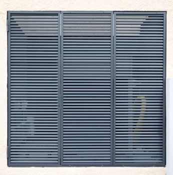 Square metal ventilation grille on a white wall