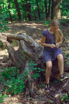 Girl sitting on a tree stump in a forest