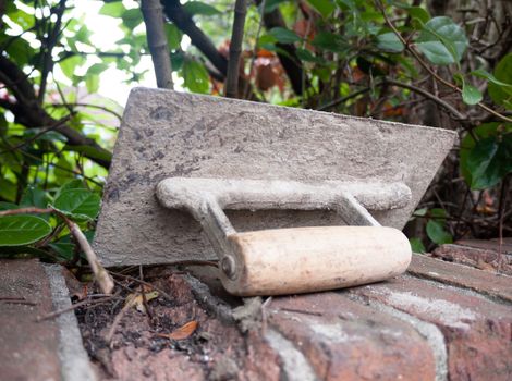 a plastering tool flat trowel resting on a wall ; UK