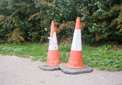 close up of two traffic cones on pavement; UK