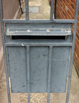 metal postbox on a gate back door rails; UK