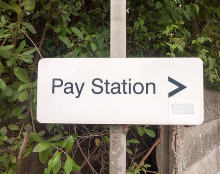 white pay station parking sign on metal post; UK