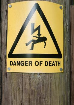 yellow danger of death sign on wooden post; UK