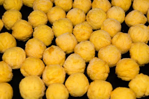 Baking tray with deep-frozen round potato croquettes made from fresh mashed potatoes.