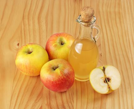 Apple cider vinegar and fresh apple on wooden background