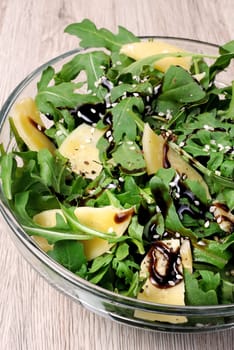 Arugula (rocket) salad dressed with balsamic soy sauce , Parmesan shavings and freshly ground black pepper, sesame.  