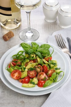 Delicate slices of avocado with tomatoes, dressed   pesto sauce.