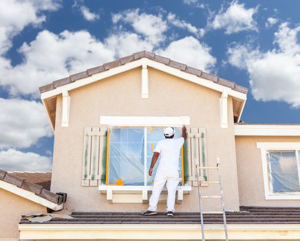 Professional House Painter Painting the Trim And Shutters of A Home.