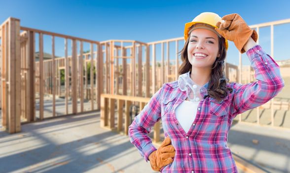 Young Attractive Female Construction Worker Wearing Gloves, Hard Hat and Protective Goggles At Construction Site.