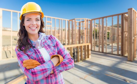 Young Attractive Female Construction Worker Wearing Gloves, Hard Hat and Protective Goggles At Construction Site.