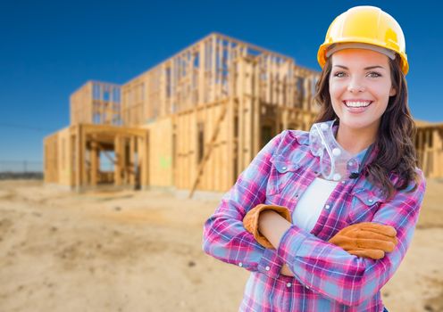 Young Attractive Female Construction Worker Wearing Gloves, Hard Hat and Protective Goggles At Construction Site.