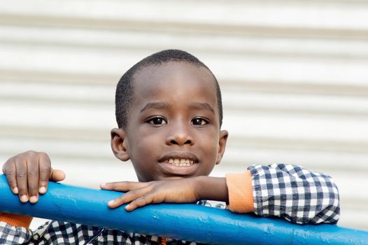 This smiling child is backed by an iron bar