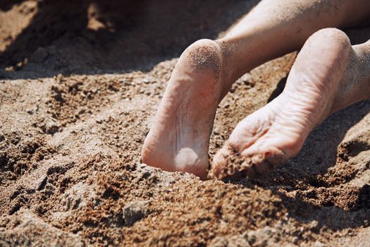 Legs of woman laying at the beach