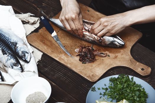 Woman preparing mackerel fish