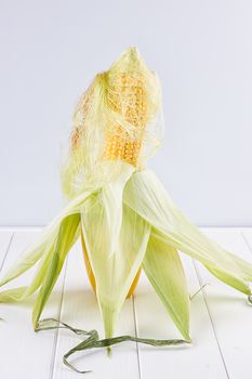 single corn on the white wooden background