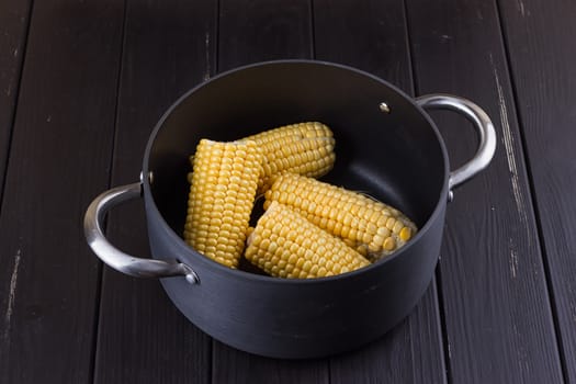 yellow gold colorful sweet maize corn boiling cooking in a large aluminum pot with charcoal outdoor on a pathway i