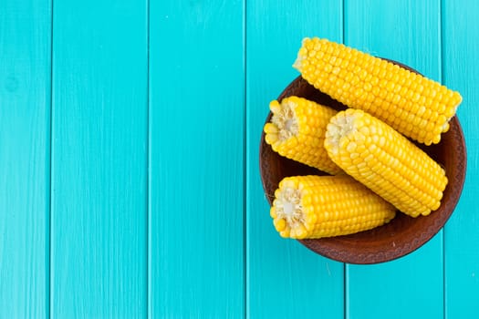 Boiled corn on a blue wood background