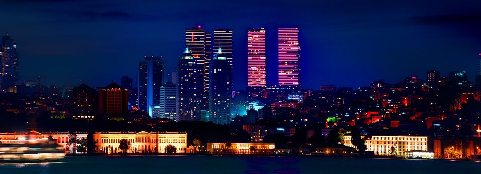 View on skyscrapers and Dolmabahce palace in european district of Istanbul at night, Turkey