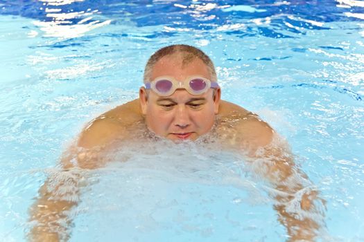 Big fat man in the swimming pool playing sports