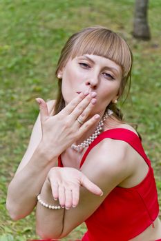 Portrait of beautiful girl in red are sending air kiss