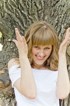 Vertical portrait of smiling beautiful girl on wood background