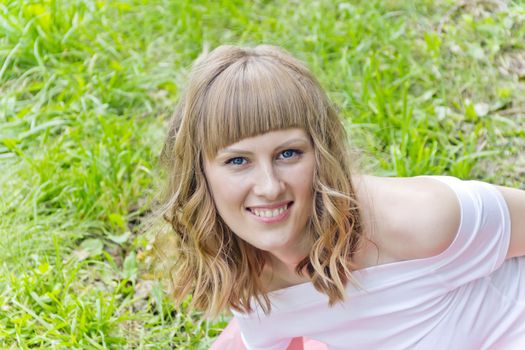 Portrait of smiling girl with blue eyes on green background