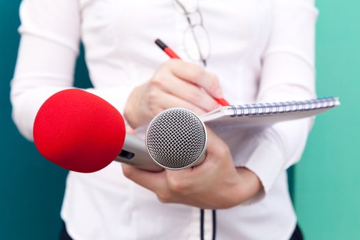 Female reporter taking notes at news conference