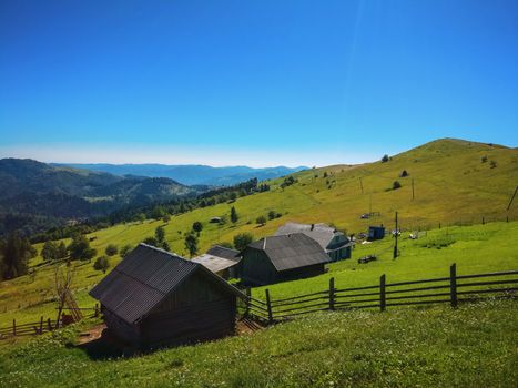A wooden hut on mountains with green beautiful meadow