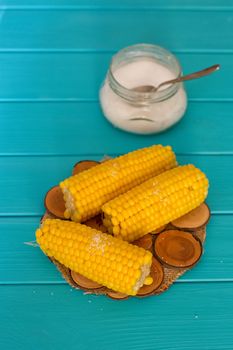 Boiled corn on a blue wood background